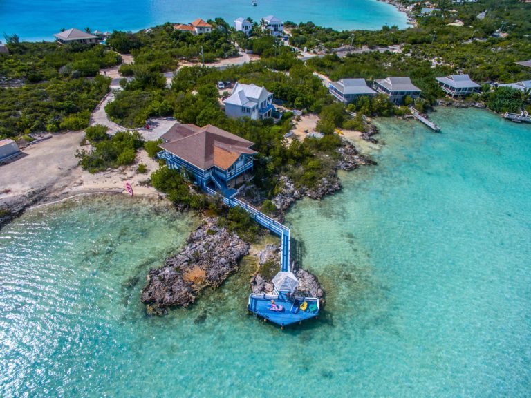 A Clear Water Beach With Cottages on the Shore