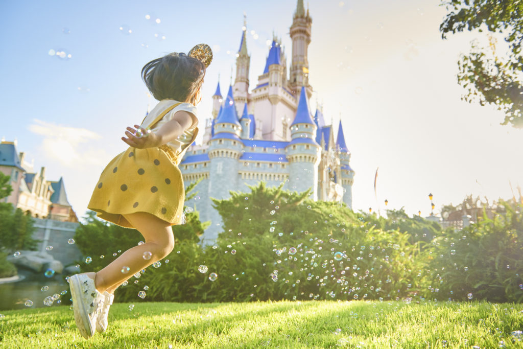 A Little Girl Jumping in Front of a Castle